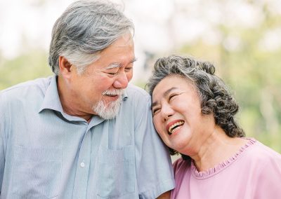 Couple walking outdoors smiling and leaning on each other