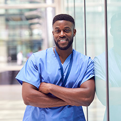 Male nurse leaning against a glass wall